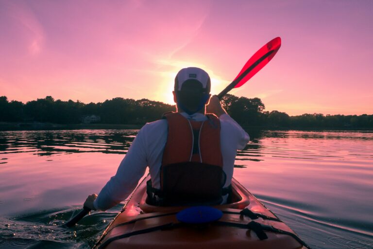 A person paddling in a kayak on a calm lake