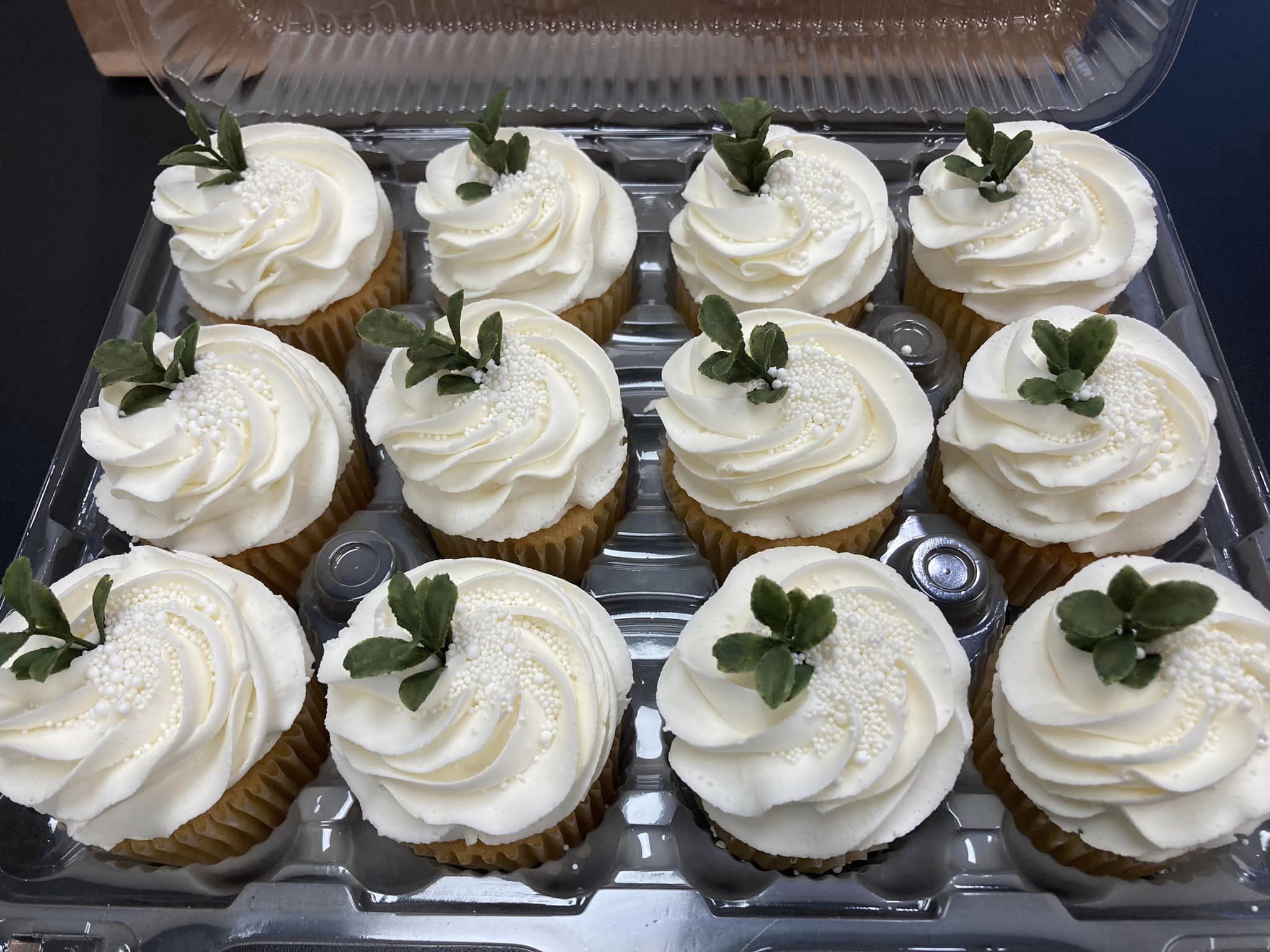 Twelve decorative cupcakes in a tray on display