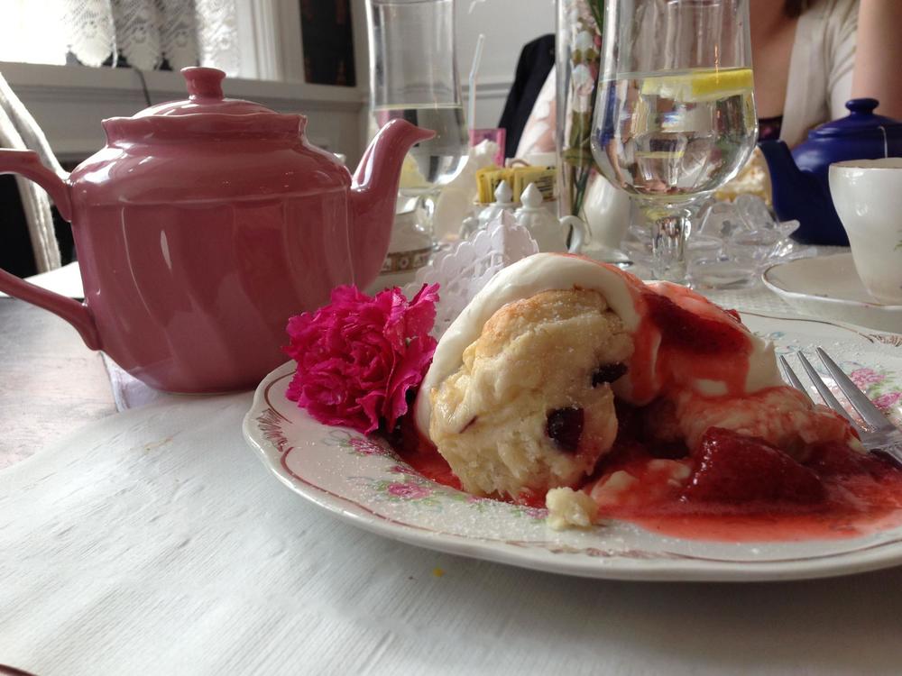 Food displayed on a plate next to a tea pot