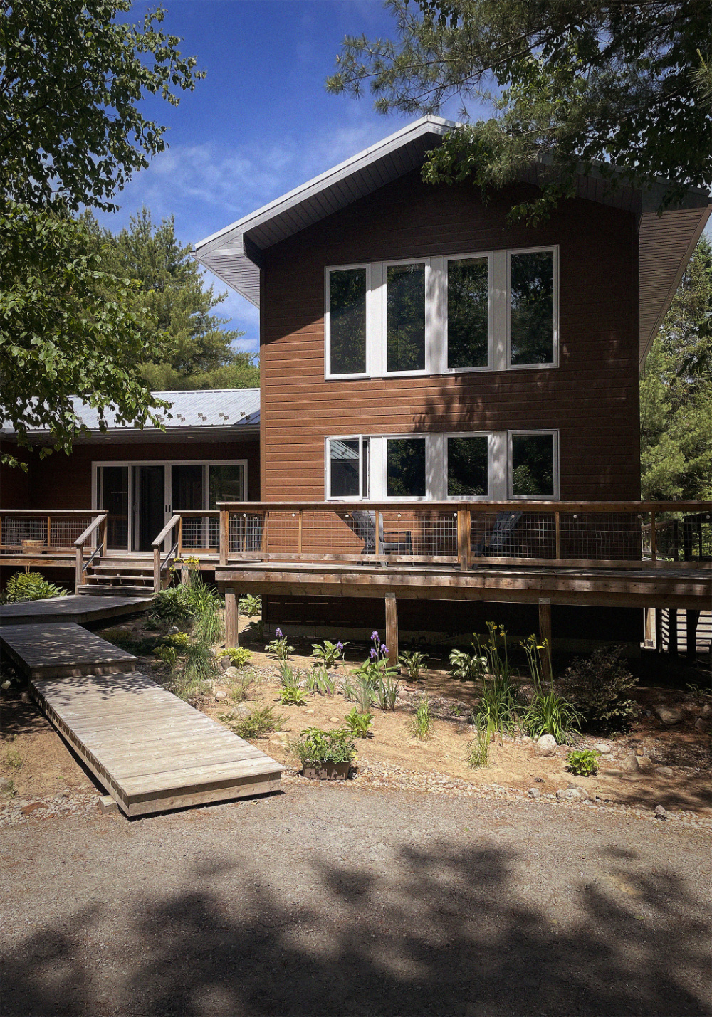 Front exterior of Cedarhaus B&B. A brown building with a large deck and white windows.