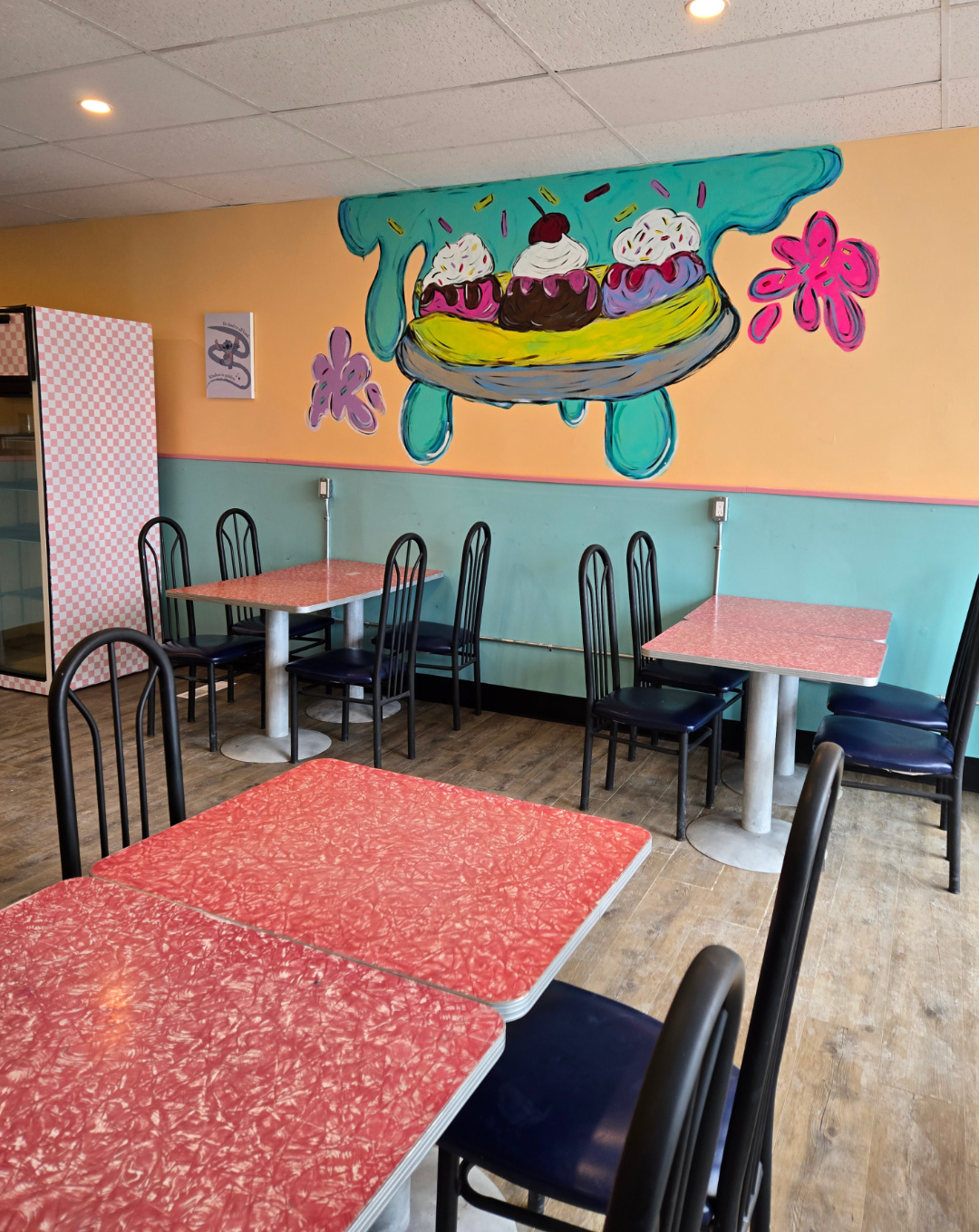 Grandma's Sweet Memories. Inside the ice cream parlor with tables and ice cream painted on the wall.