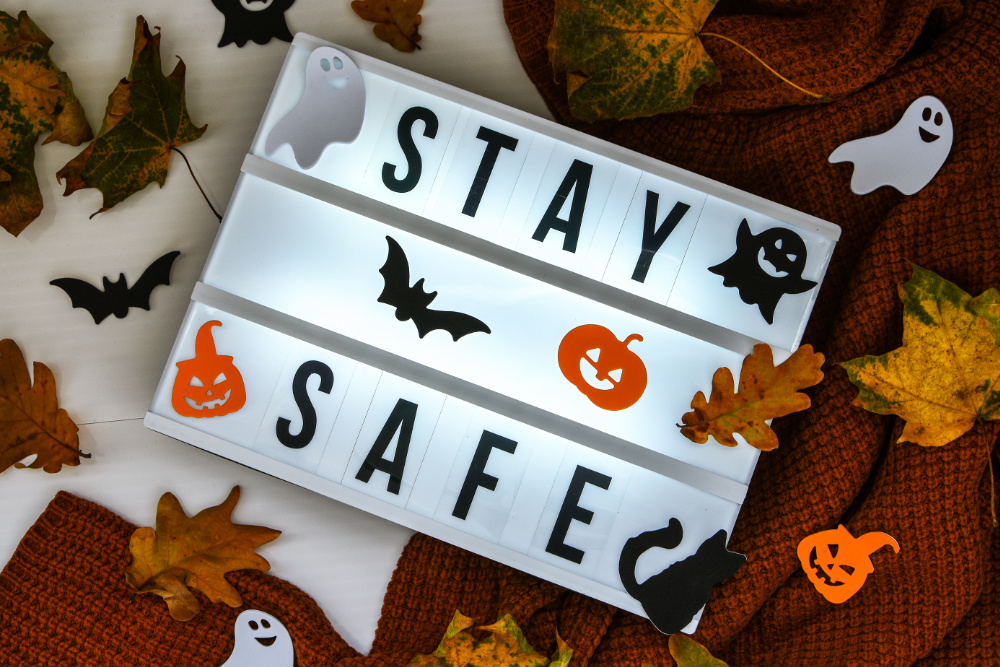 A light up sign that says Stay Safe and has little pumpkins, ghost stickers on it. 