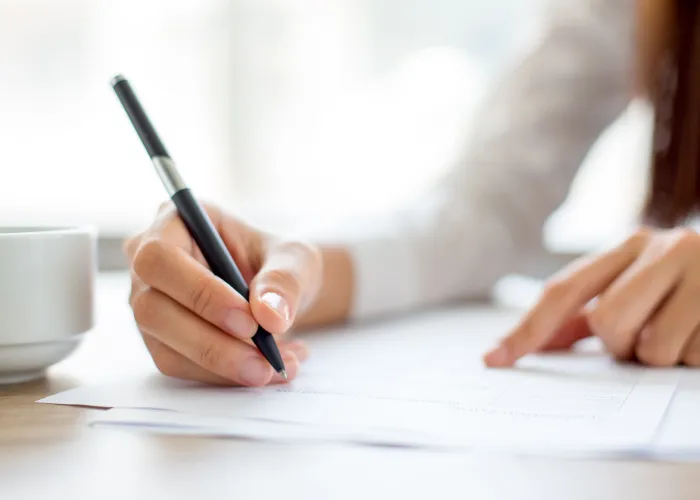 businesswoman-writing-paper-office
