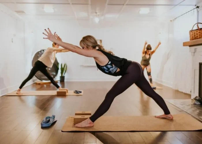 Three people practicing Yoga in a studio