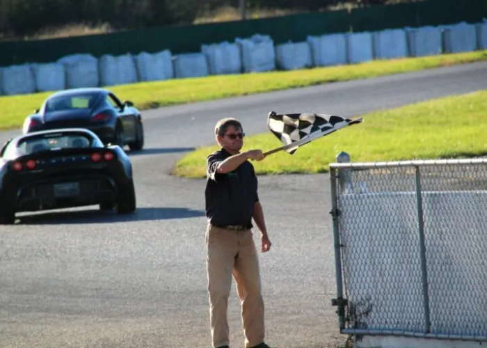 A person waving a checkered flag on a race car track