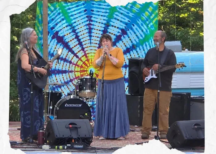 White background, photo of three band members of Canoe Conspiracy performing on stage, tie dye background, name of band and event details